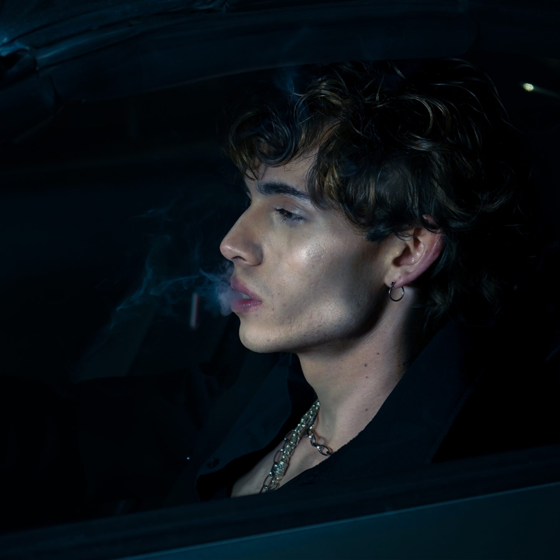 Antonius in profile through a car window at night