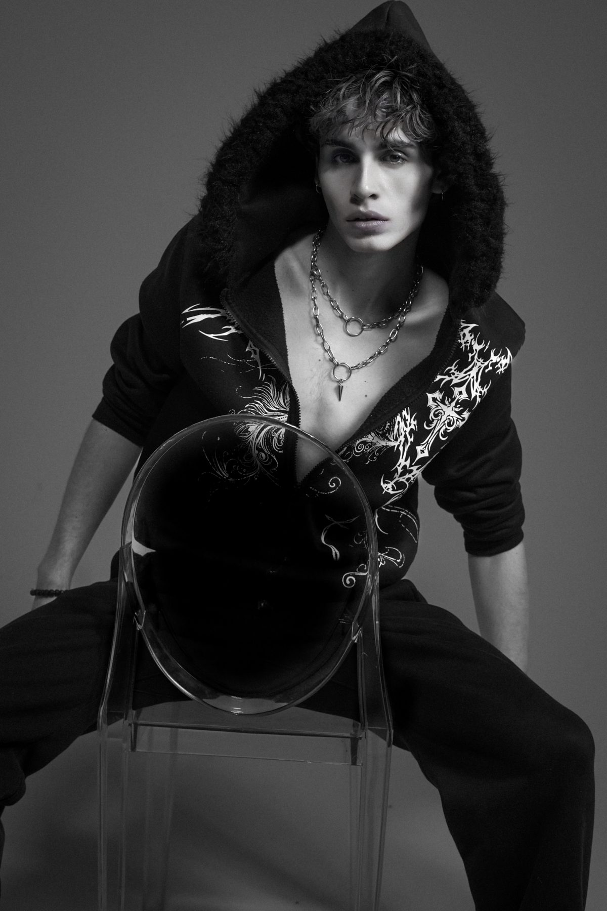 Antonius seated with acrylic chair, black and white editorial
