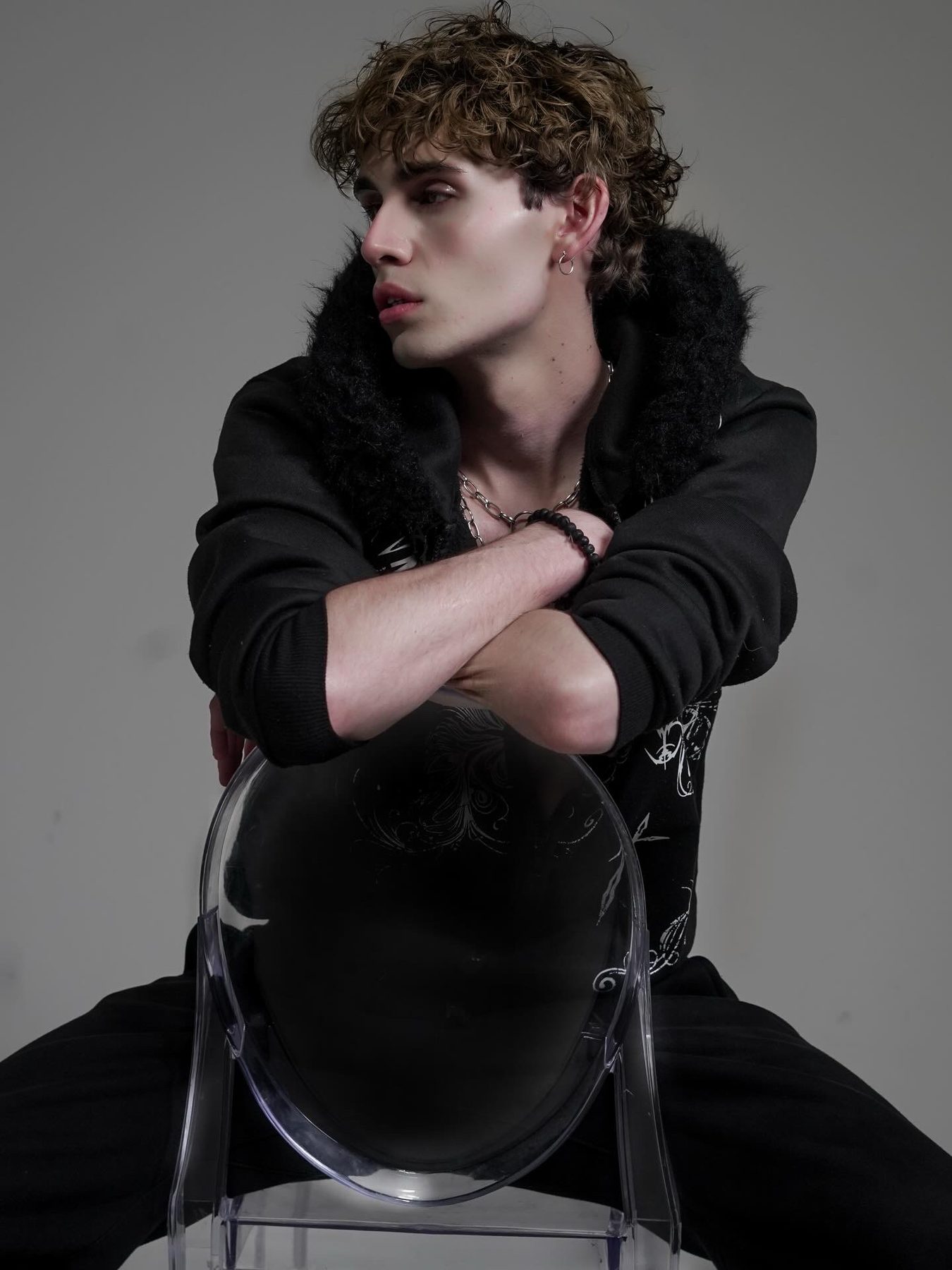 Antonius seated with arms crossed, black and white studio editorial